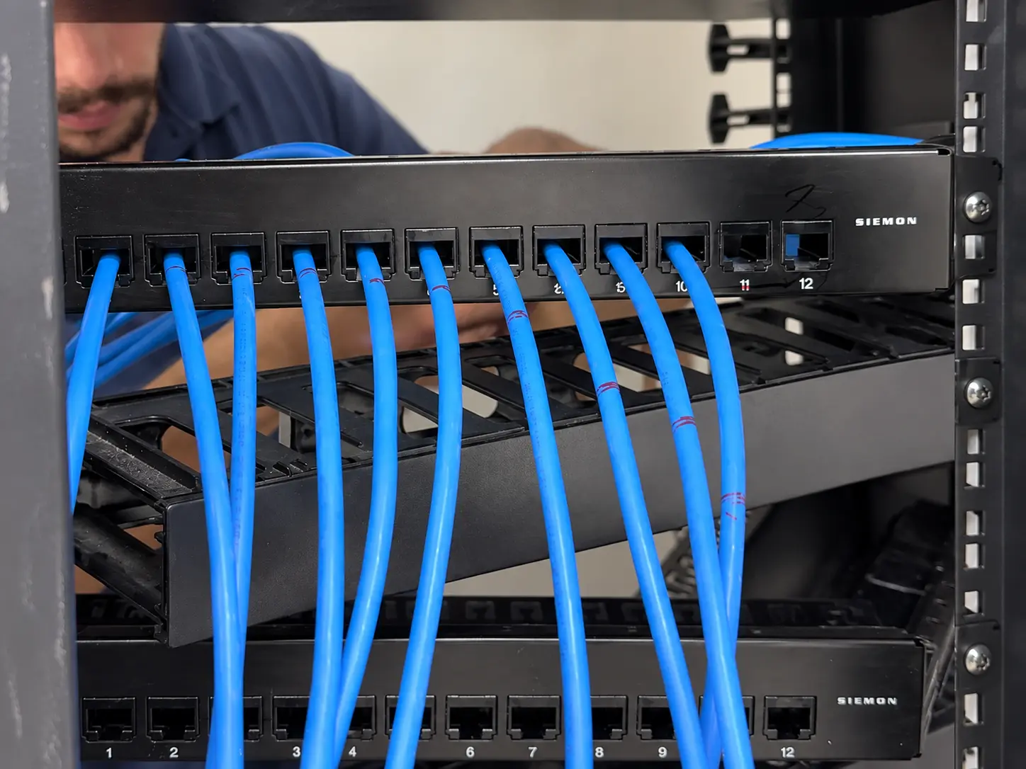 Técnico da Skills Telecom organizando cabeamento em rack